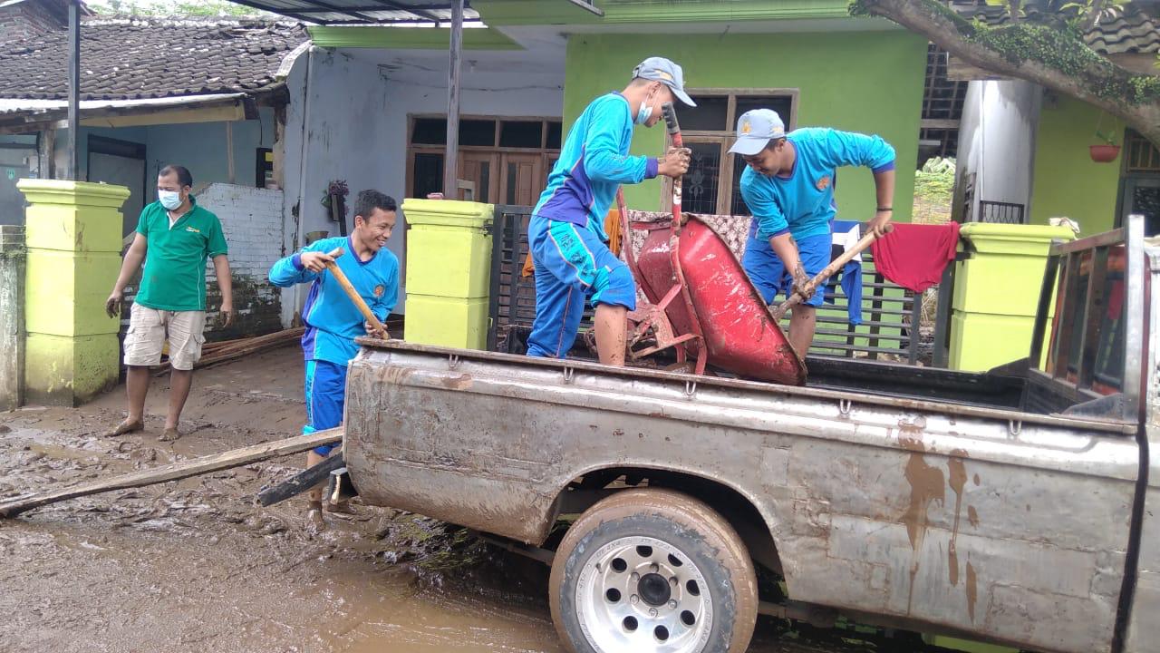 Membantu membersihkan rumah korban banjir